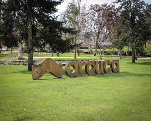 a wooden sign in the grass in a park at MS Collection Arouca - Mosteiro de Arouca in Arouca