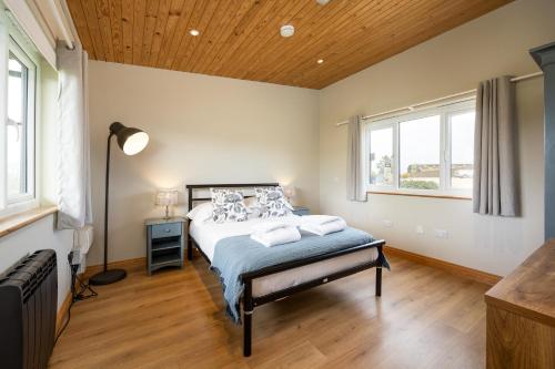 a bedroom with a bed and a wooden ceiling at Little Lodge At Tapnell Farm in Isle of Wight