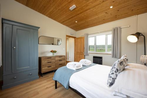 a bedroom with a bed and a dresser and a window at Little Lodge At Tapnell Farm in Isle of Wight