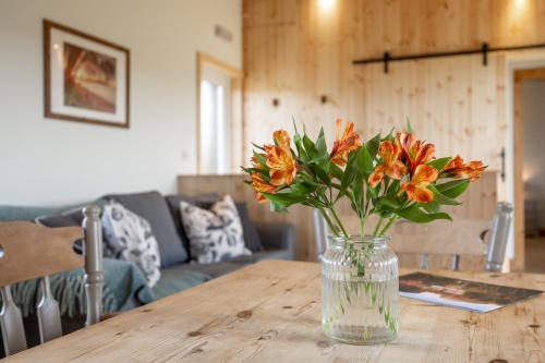 a vase of flowers sitting on a wooden table at Little Lodge At Tapnell Farm in Isle of Wight