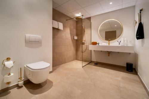 a bathroom with a toilet and a sink and a mirror at Radisson Hotel Papirfabrikken Silkeborg in Silkeborg