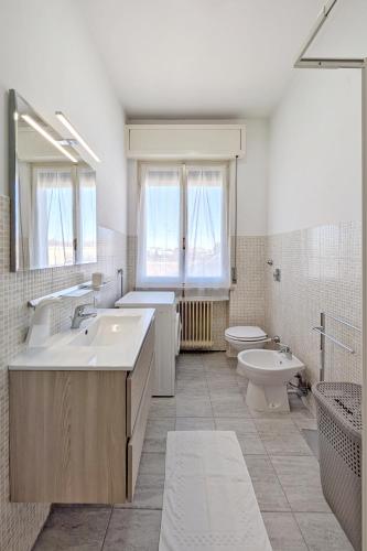a white bathroom with a sink and a toilet at Casa Vacanze Crema in Crema