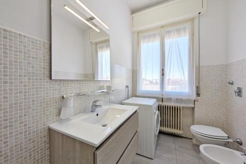 a bathroom with a sink and a toilet and a mirror at Casa Vacanze Crema in Crema