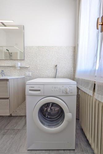 a white washing machine in a bathroom with a mirror at Casa Vacanze Crema in Crema