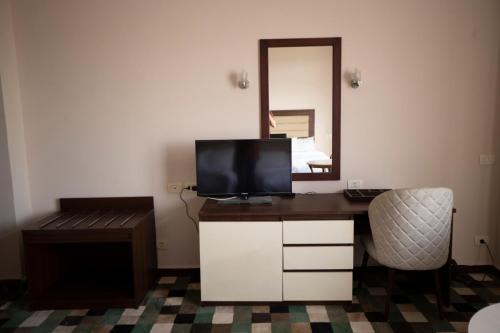 a room with a desk with a television and a mirror at Oriental grand Plaza in Madinat Al Ashir min Ramadan