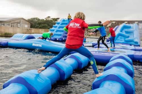 a group of people playing on an inflatable raft in the water at Little Lodge At Tapnell Farm in Isle of Wight