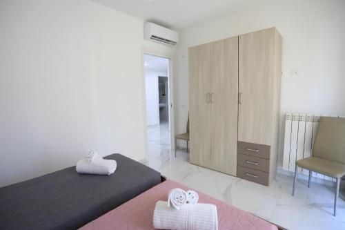 a bedroom with a bed and a cabinet and a chair at Clara Apartment in Parghelia
