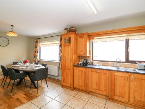 a kitchen and dining room with a table and chairs at Teach Ards in Kilgarvan