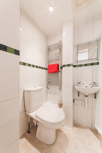a white bathroom with a toilet and a sink at 5 Bedroom House with Sea Views in Penryn