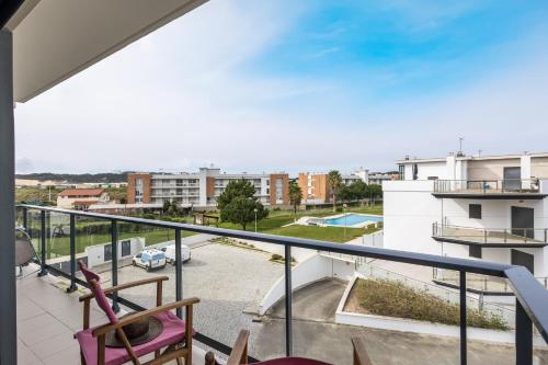 a balcony with two chairs and a view of a city at Sol e mar T3 - By Smarthomes in São Martinho do Porto