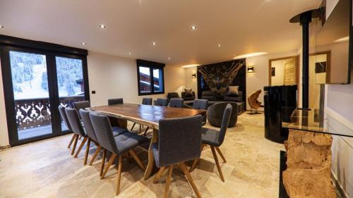une salle à manger avec une table et des chaises en bois dans l'établissement Le Montaska - Chalet 15 personnes - La Plagne, à La Plagne Tarentaise