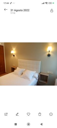 a picture of a bedroom with a bed and a lamp at Hospedaje Torreón in Cangas de Onís