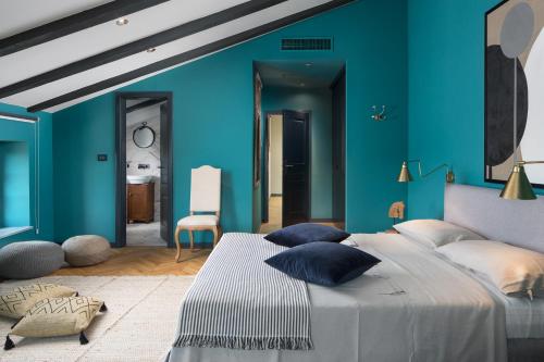 a bedroom with blue walls and a bed with pillows at Luxury Villa Covri in Brtonigla