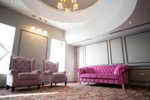a waiting room with pink couch and two chairs at Oriental grand Plaza in Madinat Al Ashir min Ramadan