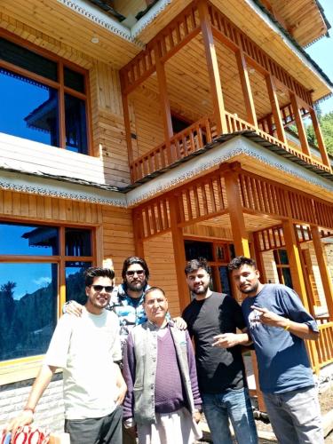 a group of people standing in front of a house at Apple Land by Naavagat in Jibhi