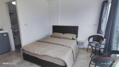 a bedroom with a bed and a table and chairs at ภูโอบตะวันรีสอร์ต - Phu Oab Tawan Resort in Nan