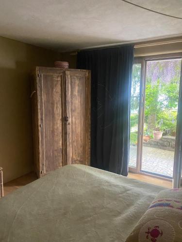 a bedroom with a bed and a large window at Vu sur le lac et les neiges éternelle in Thun