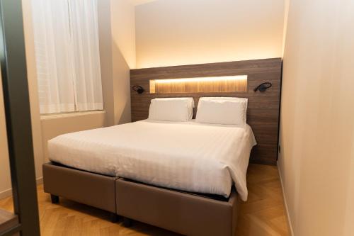 a bedroom with a bed with white sheets and pillows at Residence Villa Bottacin in Trieste