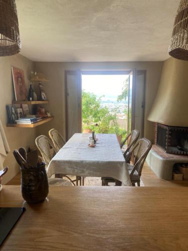 a dining room with a table and chairs and a window at Vu sur le lac et les neiges éternelle in Thun