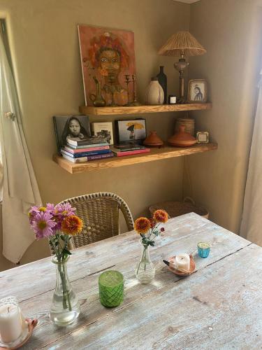 a table with two vases with flowers on it at Vu sur le lac et les neiges éternelle in Thun