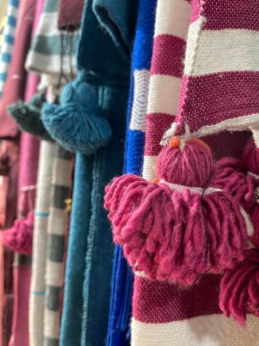 a row of colorful towels hanging on a rack at Joli appartement à Essaouira in Essaouira