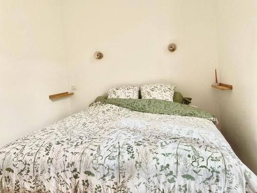 - une chambre avec un lit et une couette blanche et verte dans l'établissement Grand studio rénové avec goût au coeur d'Angers, Centre des Congrès, à Angers