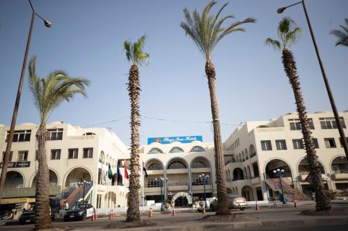 a group of palm trees in front of a building at Oriental grand Plaza in Madinat Al Ashir min Ramadan