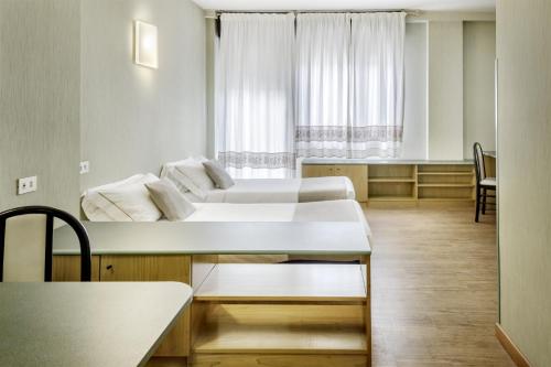 a living room with two beds and a table at Best Western Hotel Residence Italia in Quartu SantʼElena