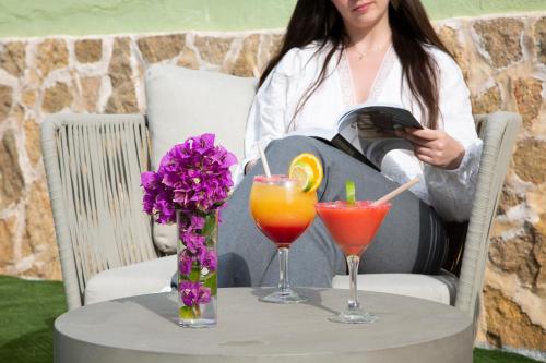 a woman sitting at a table with two cocktails at Casual Bahía Ibiza in San Antonio Bay