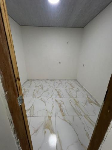 an empty room with a marble floor and a door at Eri House Home in Ananindeua