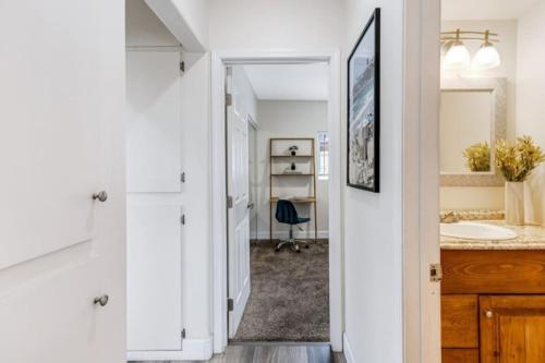 Un baño blanco con lavabo y espejo. en Bridge Pool Spa Min to Downtown Freeways Beaches, en San Diego