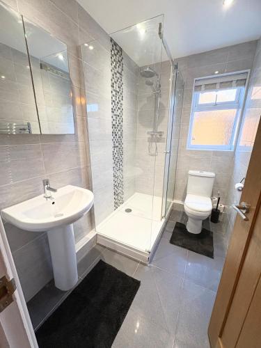 a bathroom with a sink and a shower and a toilet at Beacon cottage in Skegness