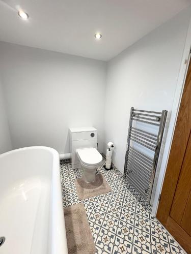 a bathroom with a bath tub and a toilet at Beacon cottage in Skegness