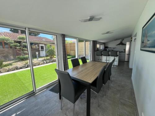 une salle à manger avec une table et des chaises en bois dans l'établissement Location maison balnéaire 8 couchages 50m plage du Cormier, à La Plaine-sur-Mer