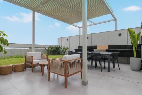 a patio with a table and chairs and a patio umbrella at Pod by Wynwood House in Lima