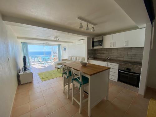 a kitchen with a table and chairs and a view of the ocean at studio with sea view in Salema