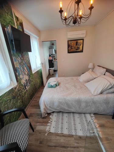 a bedroom with a large bed and a chandelier at La Mandragore in La Teste-de-Buch