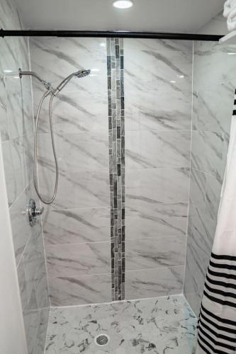 a bathroom with a shower with a glass door at One Bed Retreat in Long Branch in Long Branch