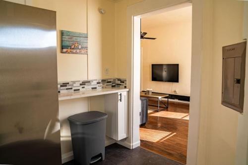 a living room with a trash can and a television at One Bed Retreat in Long Branch in Long Branch