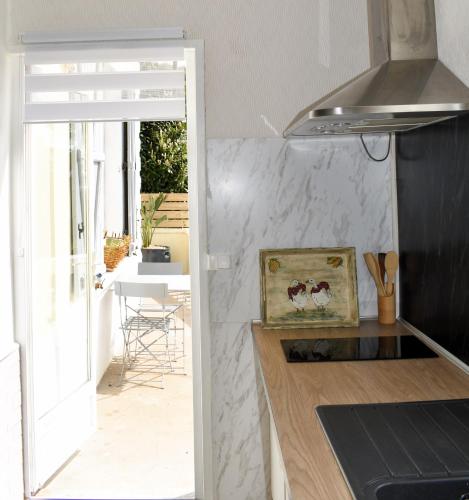 Il comprend une cuisine avec un comptoir et une porte donnant sur une terrasse. dans l'établissement Le Côteau du Segala, à Villefranche-de-Rouergue