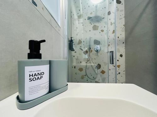 a bottle of hand soap sitting on a bathroom sink at WelcHome Vitorchiano in Vitorchiano