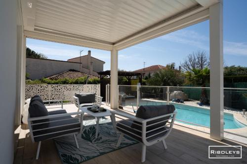 un patio avec une table et des chaises et une piscine dans l'établissement Villa T4bis climatisée avec piscine privée et WIFI, à Vias