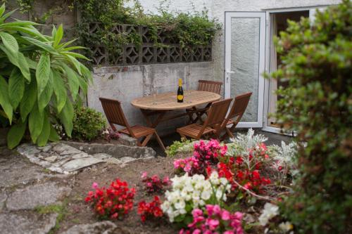 a wooden table with chairs and a bottle of wine at 5 Bedroom House with Sea Views in Penryn