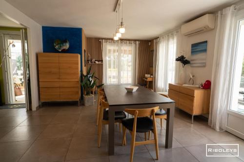 - une cuisine avec une table à manger et des chaises dans l'établissement Villa T4bis climatisée avec piscine privée et WIFI, à Vias