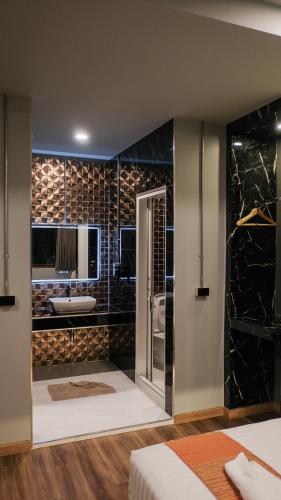 a bathroom with a shower and a sink in a room at Lorjula INN in Hat Yai