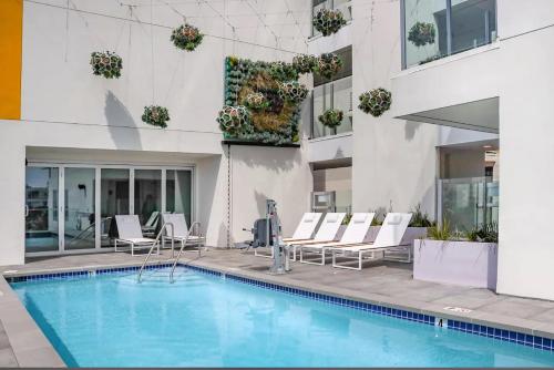 a hotel swimming pool with chairs and a building at Lovely Studio in heart of Hollywood in Los Angeles