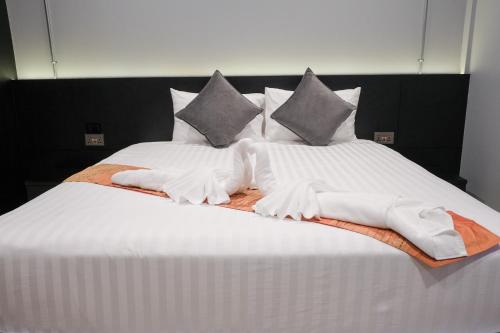 a large bed with white towels and pillows on it at Lorjula INN in Hat Yai