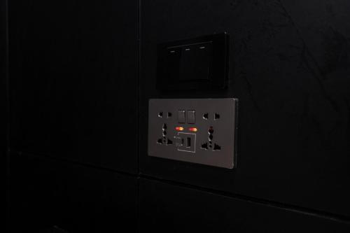a lightswitch on a wall in a dark room at Lorjula INN in Hat Yai