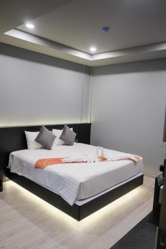 a bedroom with a large bed with white sheets at Lorjula INN in Hat Yai