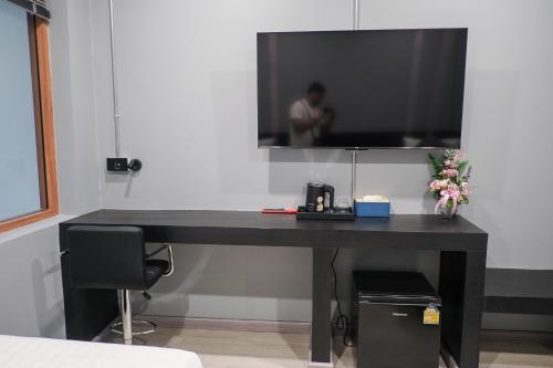 a black desk with a television on a wall at Lorjula INN in Hat Yai